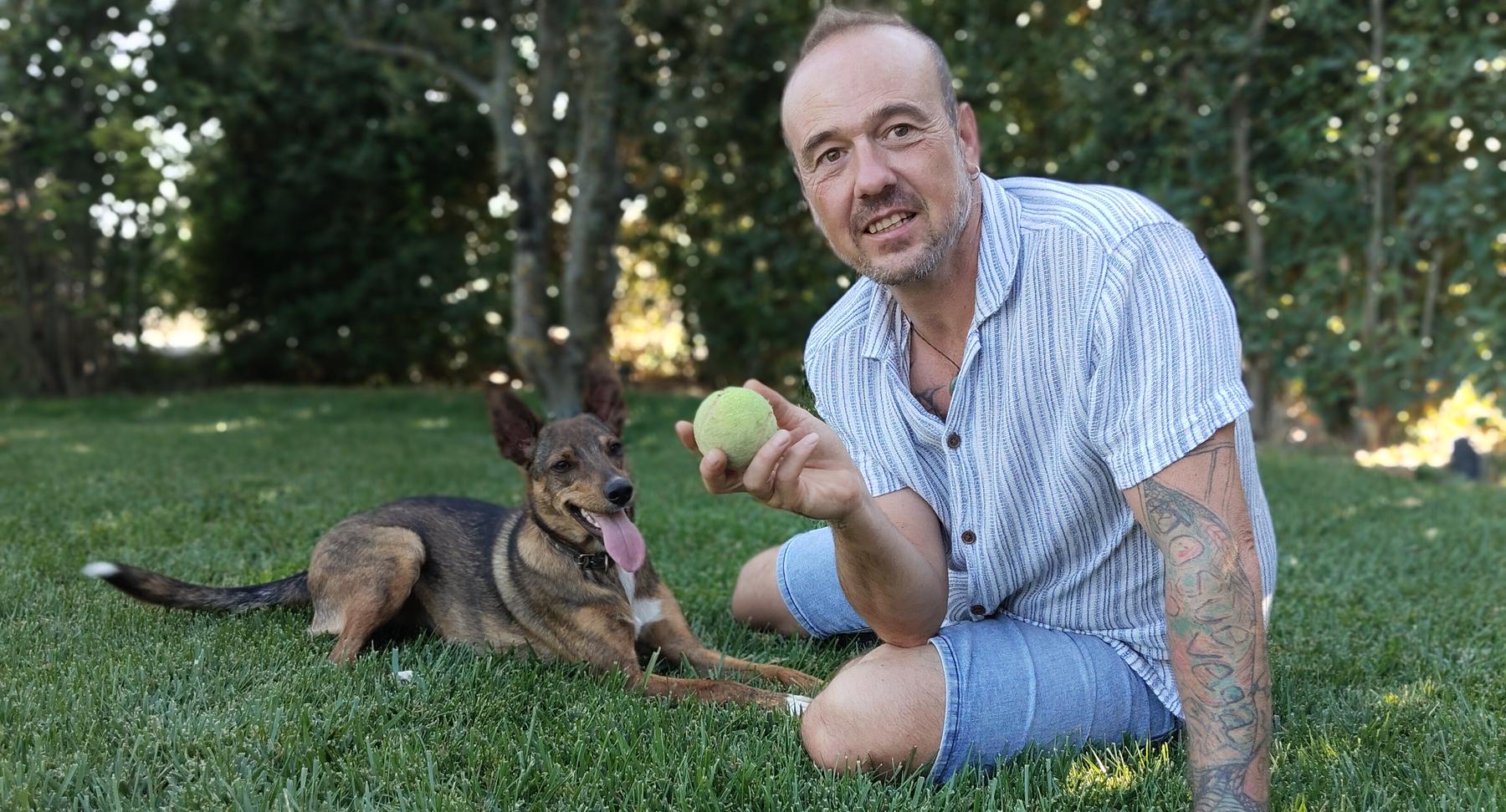 Miguel tumbado en la hierba junto a su perro